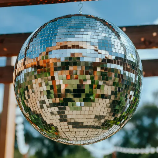 Mirror disco ball hanging from a wooden pergola